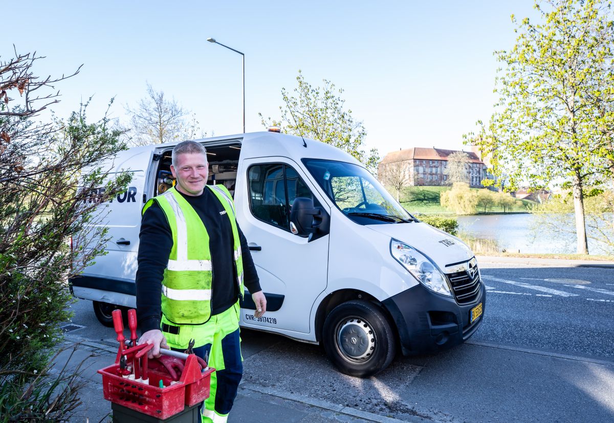 Copperline plumber beside the company van with a tool crate